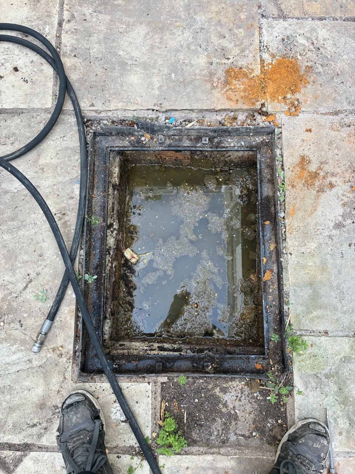 Blocked drain chamber standing full of water in Bristol before clearance